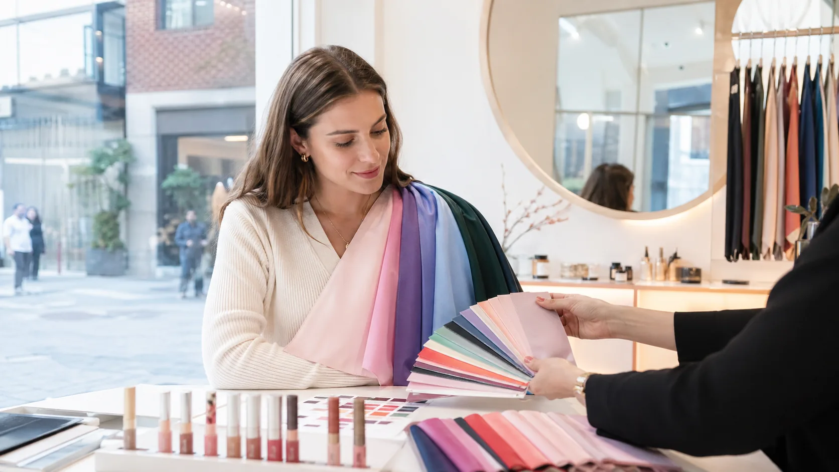 A traveler in a Seoul personal color studio comparing fabric swatches during a K-beauty consultation.